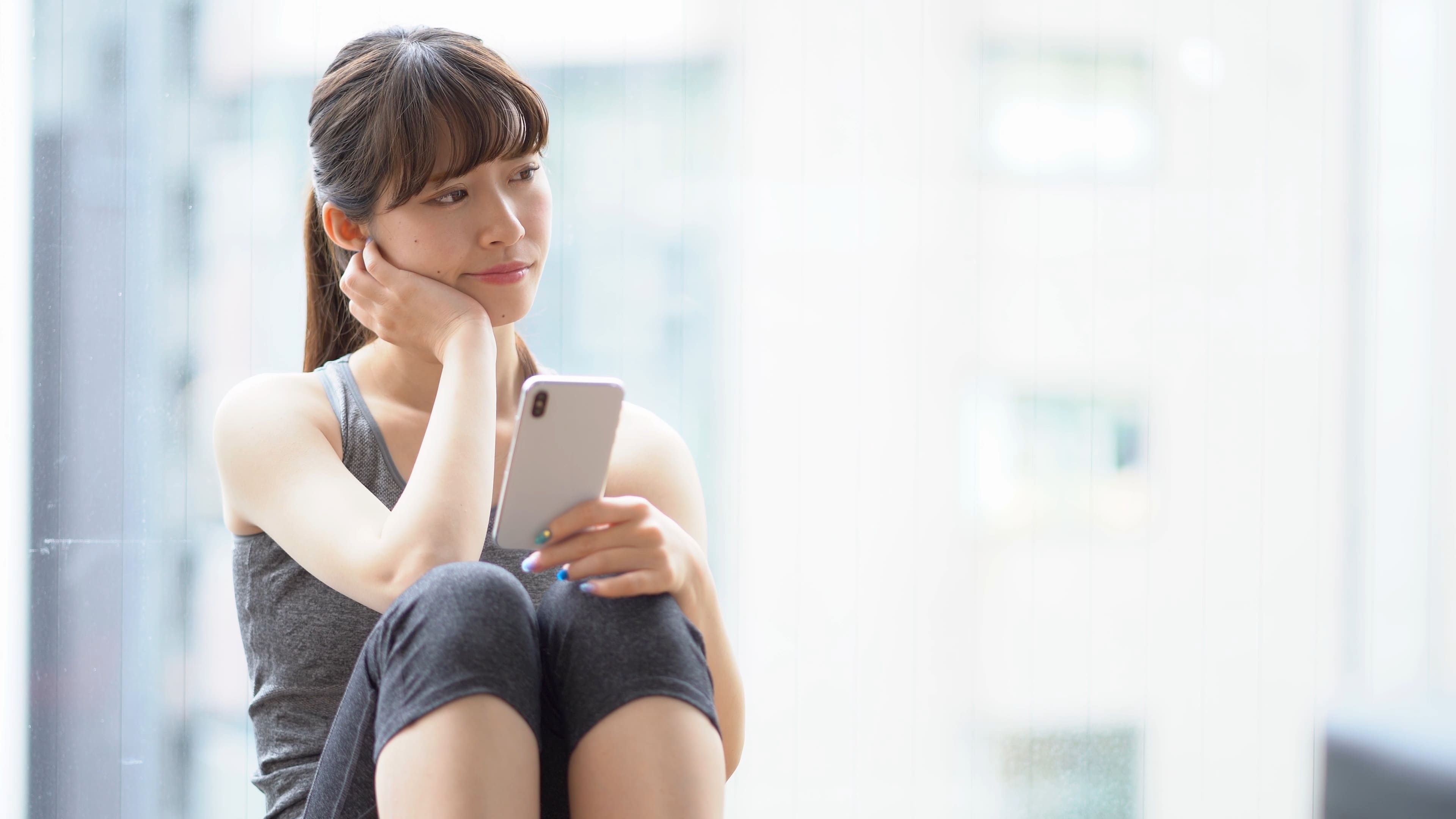 窓辺で静かに考え事をする女性